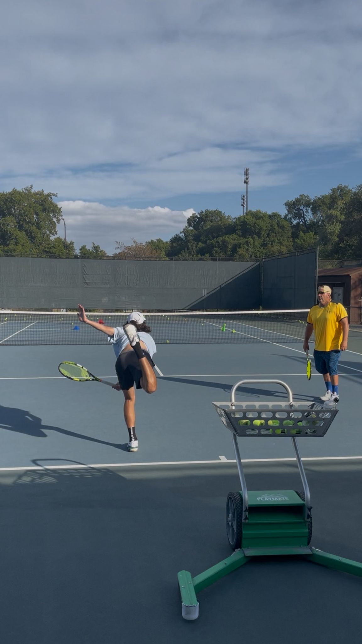 Student practicing tennis serve